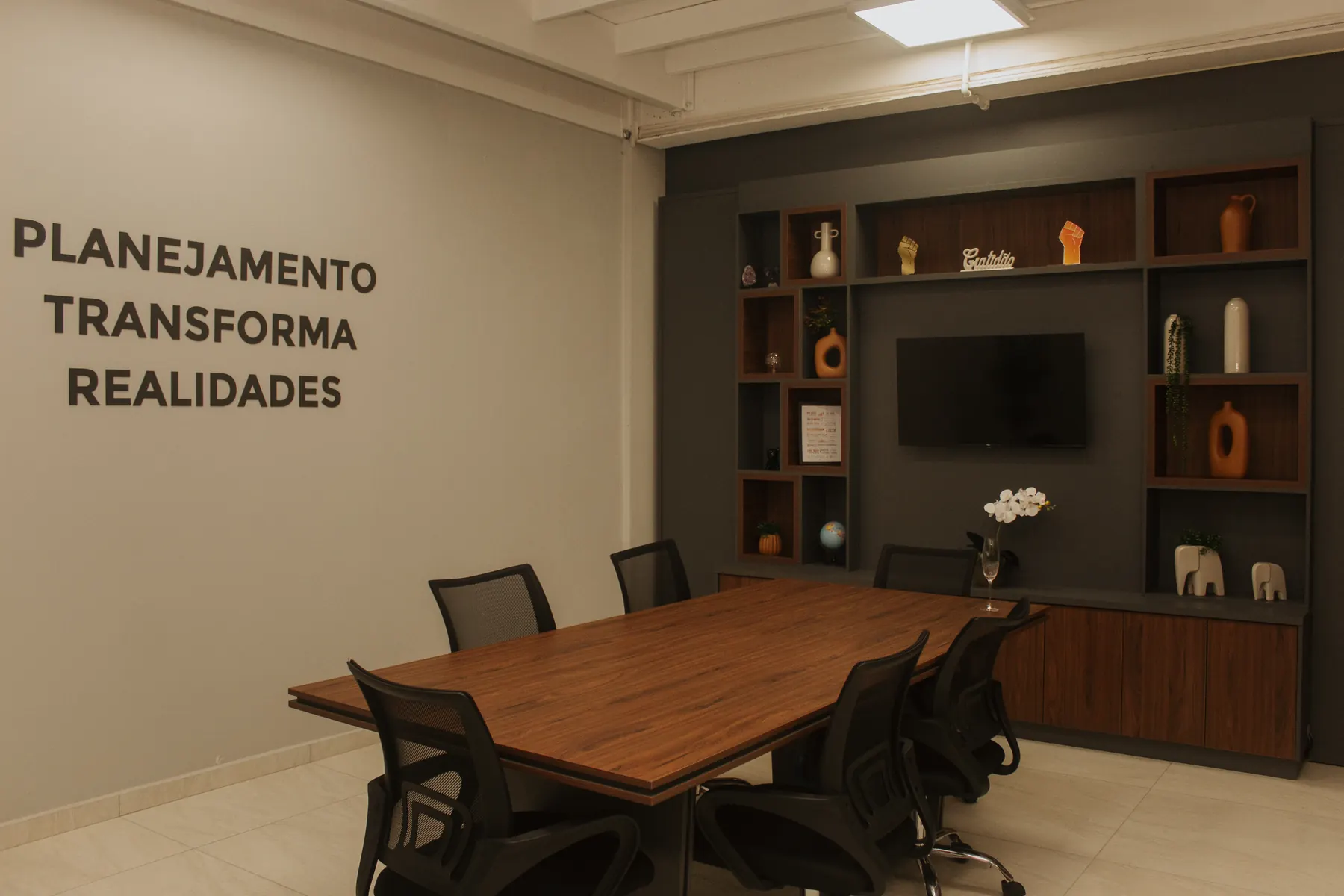 Sala de reunião com a frase Planejamento transforma realidades
